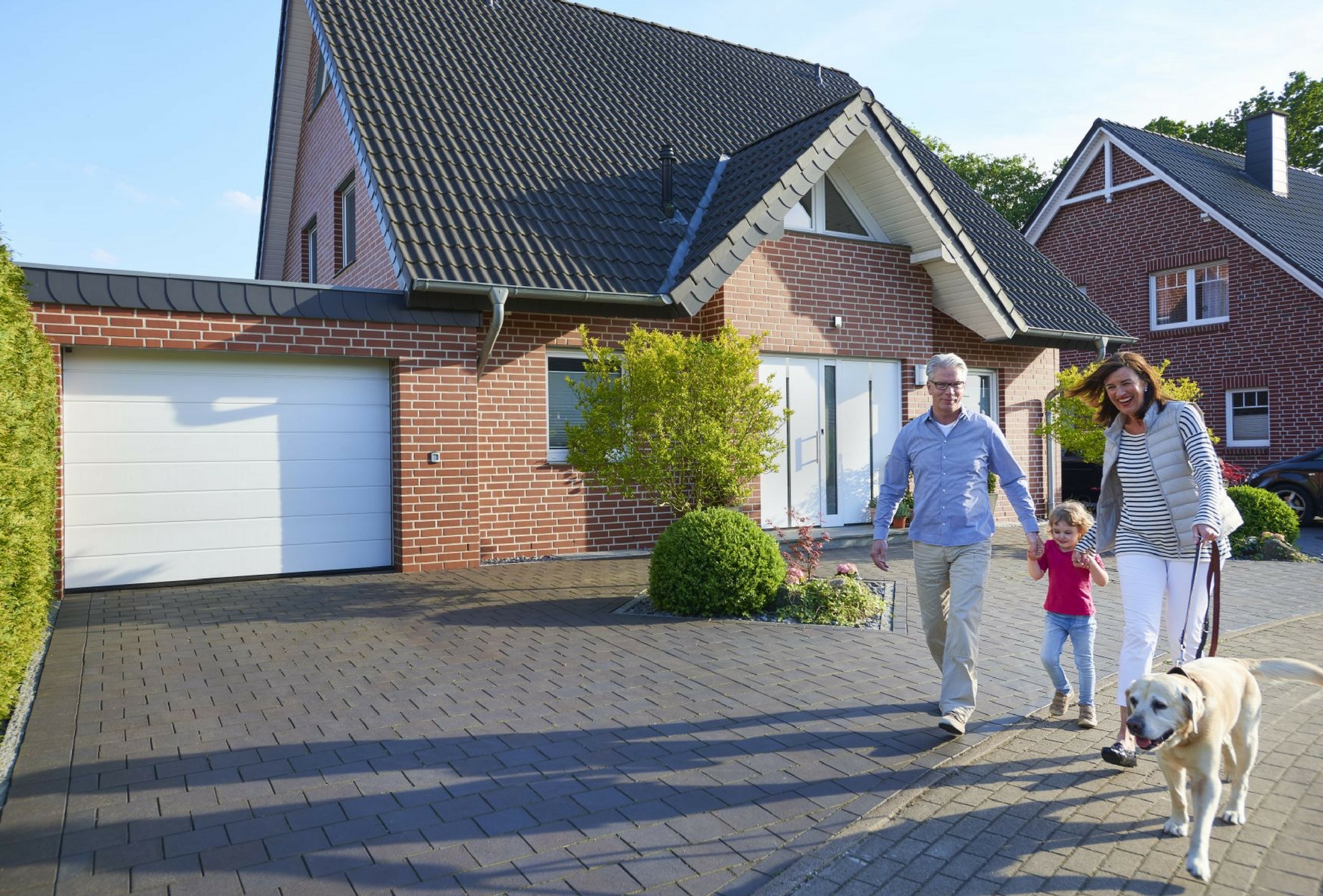 Familie vor sicherem Haus mit hoher Einbruchsicherheit